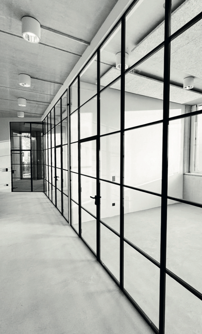 Großflächige Stahl-Glas-Trennwände als Büroabtrennung in modernem Großraumbüro