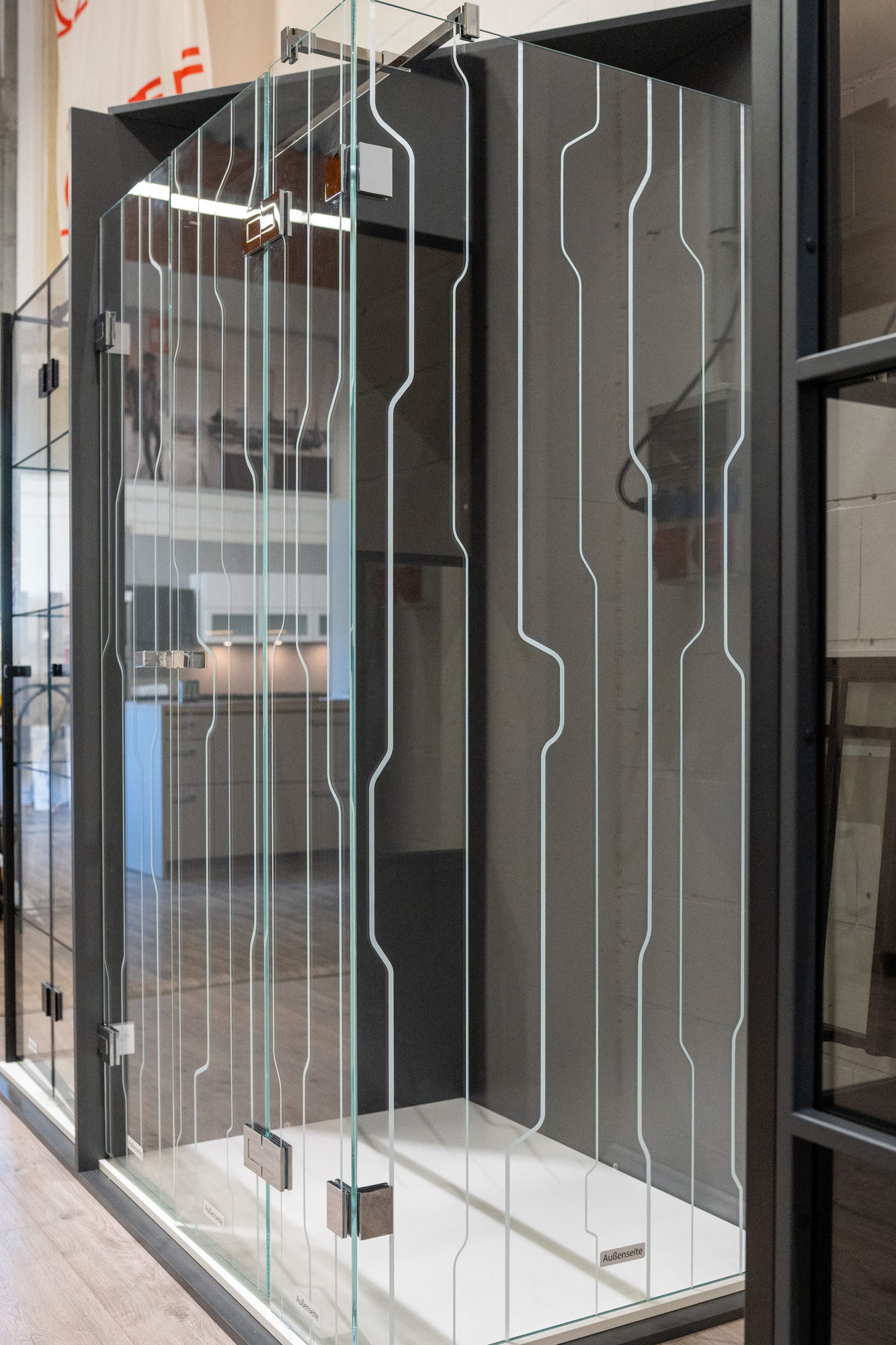 Vollglasdusche aus Echtglas mit Streifendekor und Edelstahlbeschlägen in der Ausstellung, Glasdusche nach Maß für Büren