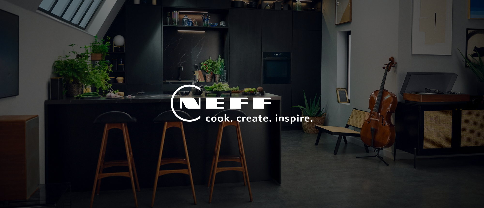 Neff Logo mit dem Claim cook. create. inspire. über einer anthrazitfarbenen Küche mit Kochinsel